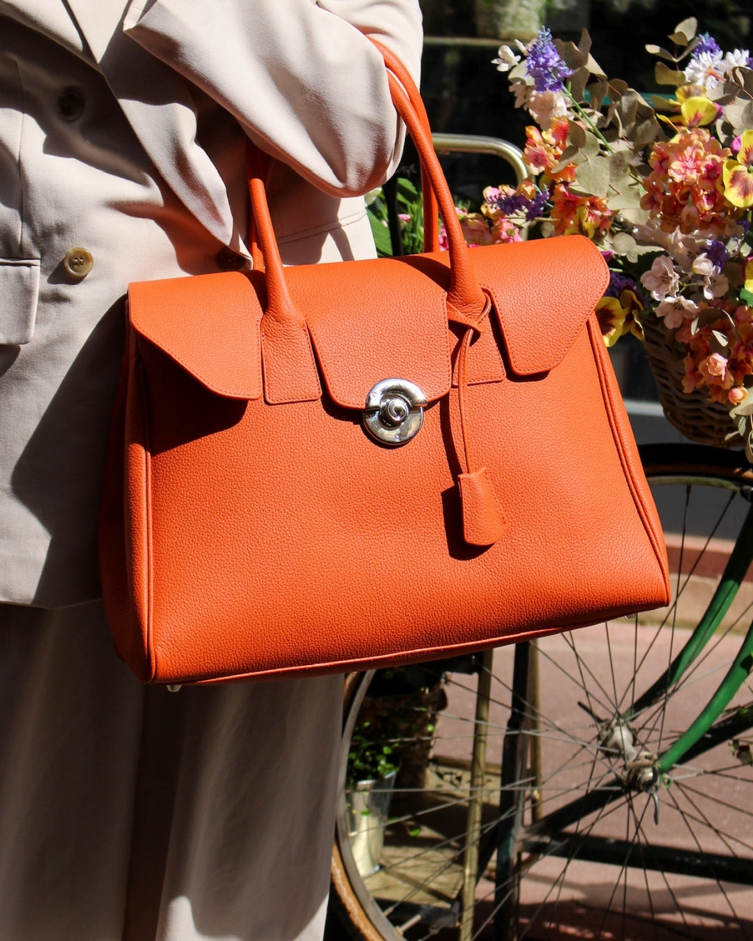 Femme portant sac Cortina cuir orange à la main en ville