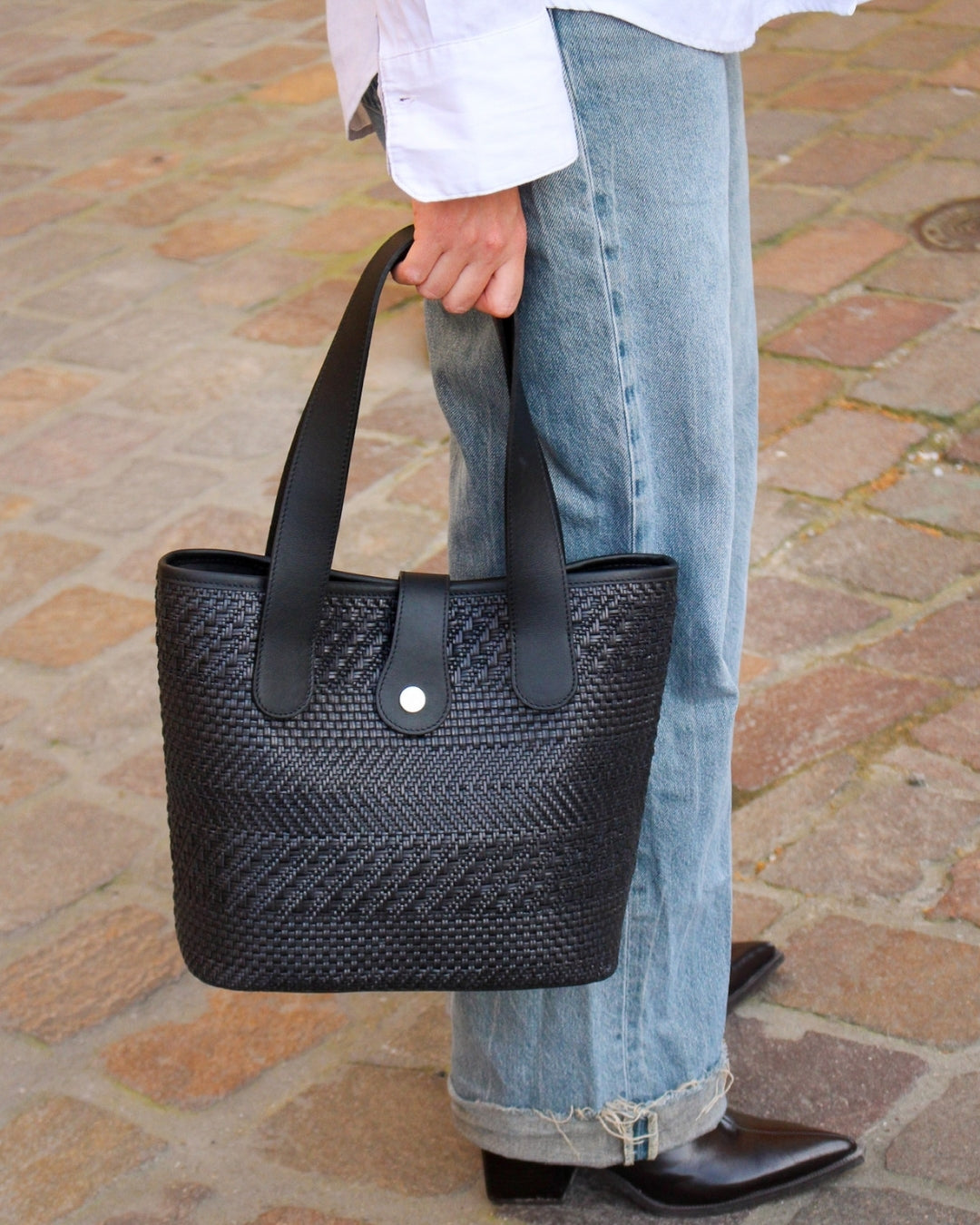 Femme portant sac Saint Barth cuir tressé noir à la main