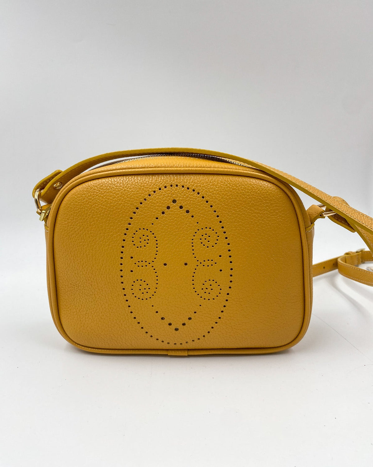 Pochette Trianon en cuir jaune moutarde vue de face, motif perforé bout fleuri et bandoulière en cuir, fabriquée en France par Berthille