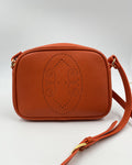 Pochette Trianon en cuir orange vue de face, motif perforé bout fleuri et bandoulière en cuir, fabriquée en France par Berthille