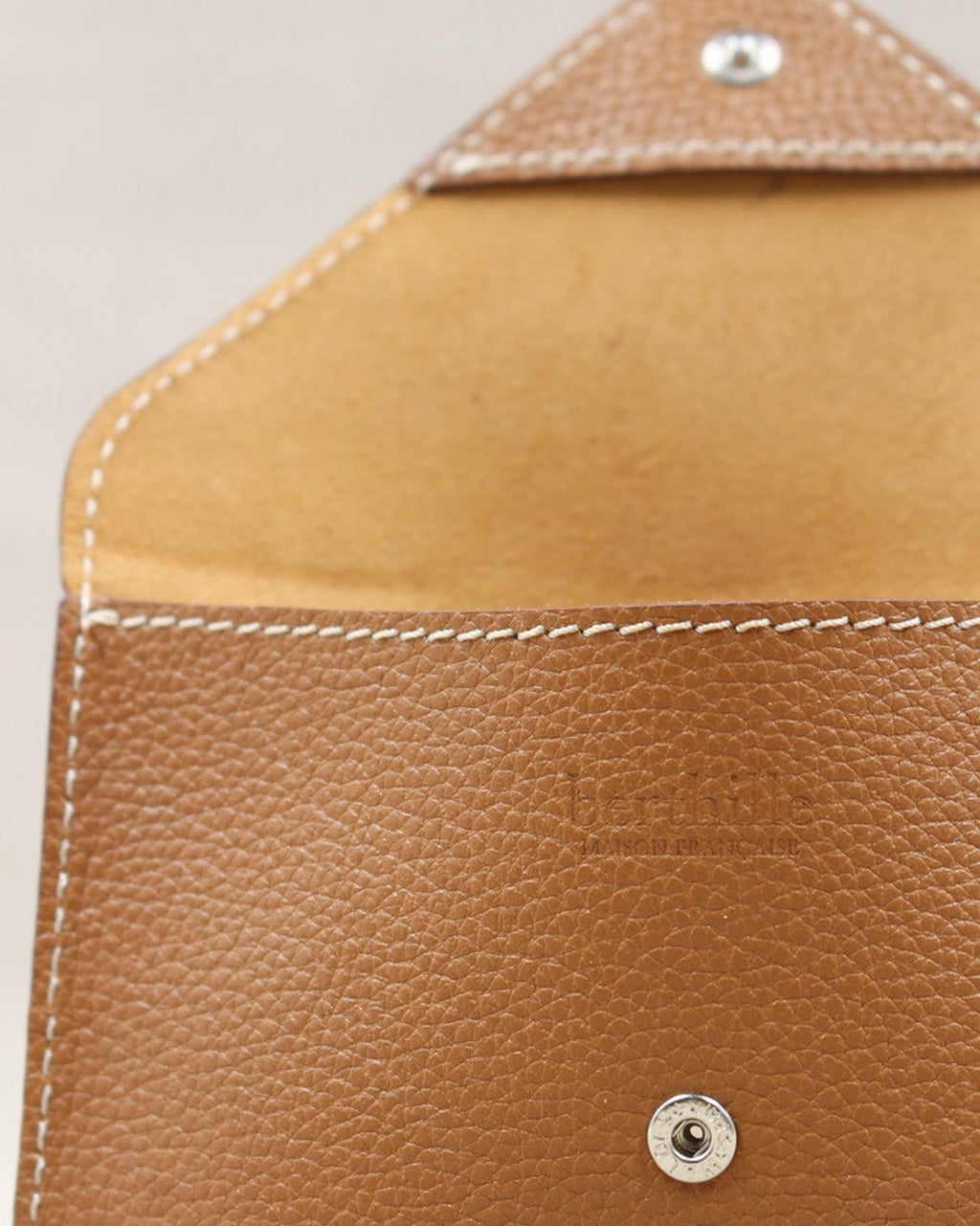 Détail de la pochette Lutecia en cuir pleine fleur Cuero, finitions cousues main, maison Berthille