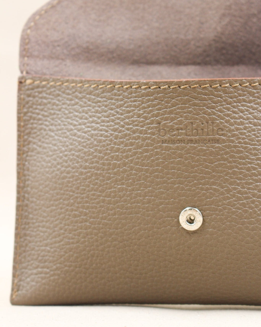 Détail de la pochette Lutecia en cuir pleine fleur Havane, façonnée à la main à Mazamet