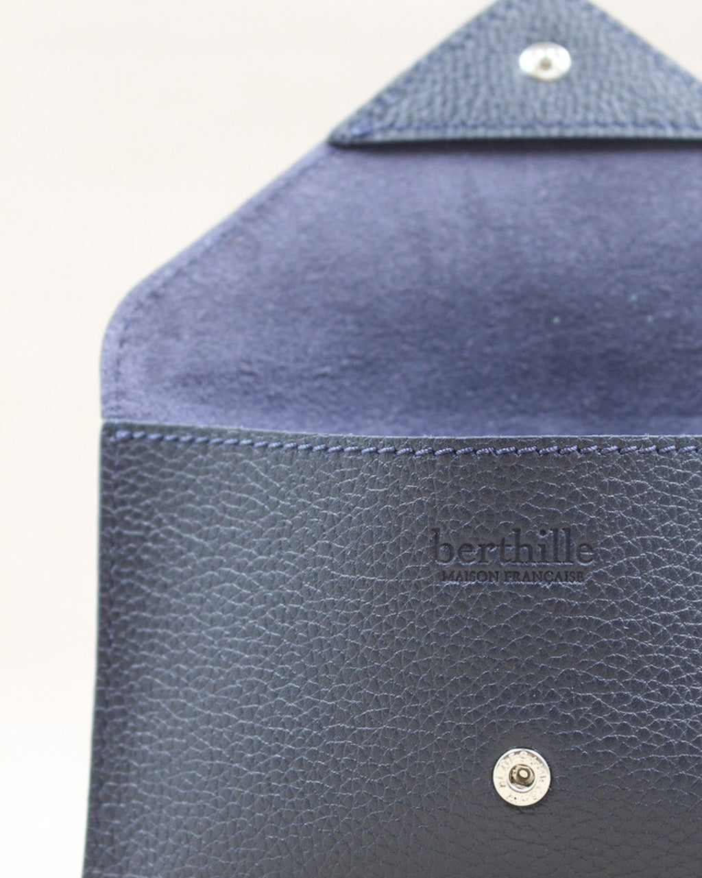 Détail de la pochette Lutecia en cuir pleine fleur Marine, façonnée à la main à Mazamet