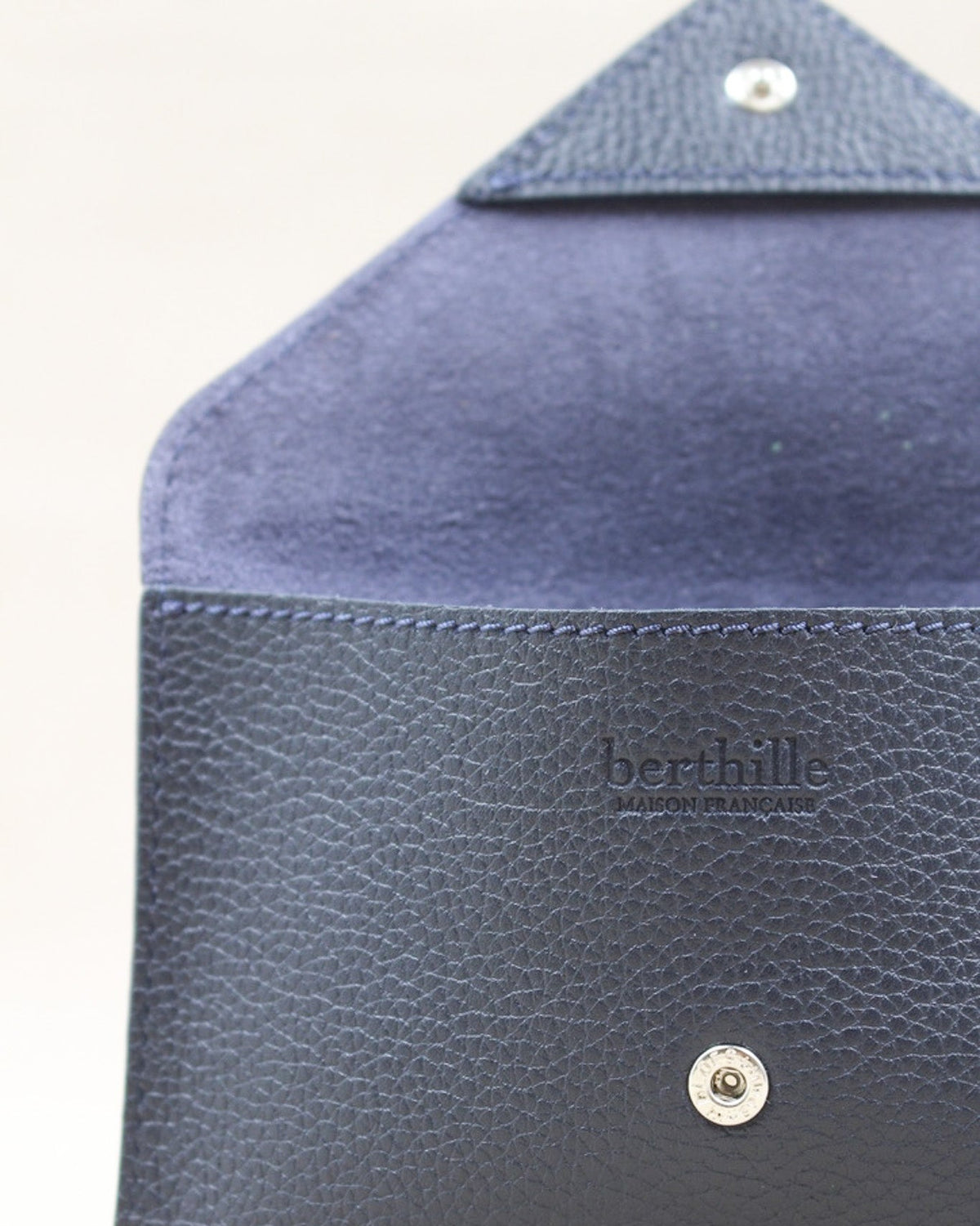 Détail de la pochette Lutecia en cuir pleine fleur Marine, façonnée à la main à Mazamet