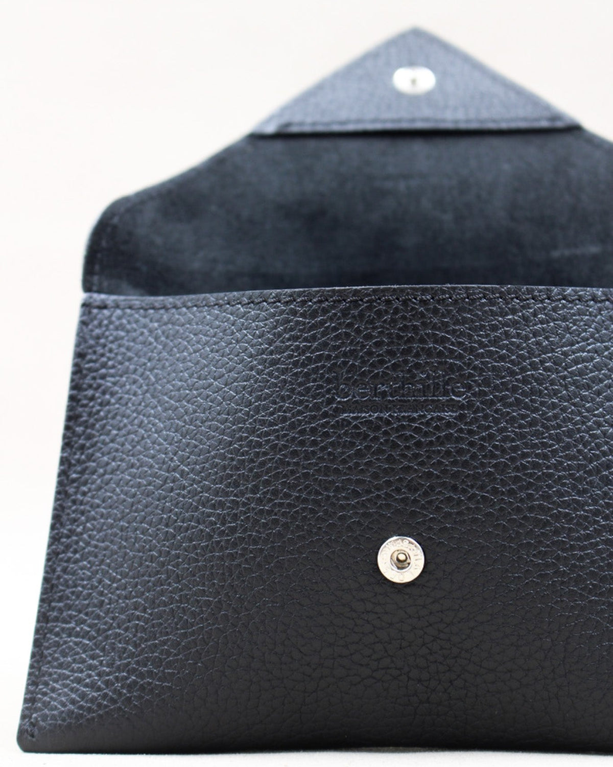 Détail de la pochette Lutecia en cuir pleine fleur Noir, fermeture pression, façonnée à Mazamet
