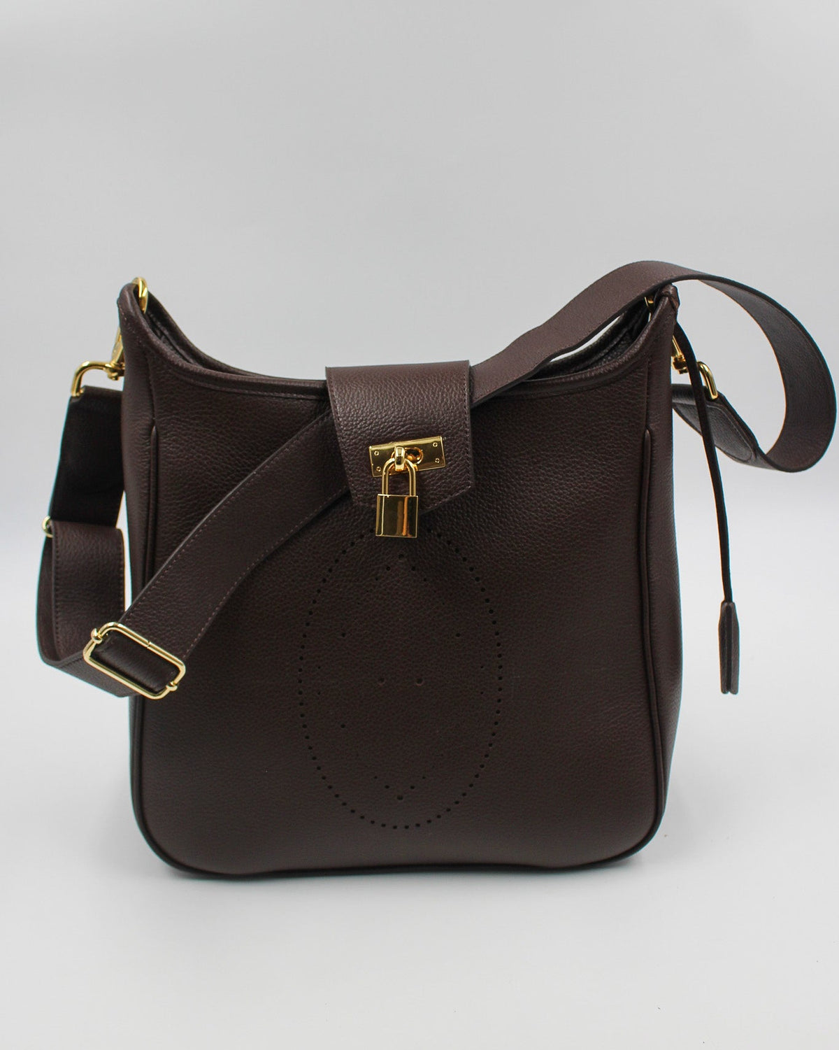 Sac Trianon grand format en cuir chocolat vue de face, motif perforé bout fleuri, cadenas doré et large bandoulière réglable, fabriqué en France par Berthille