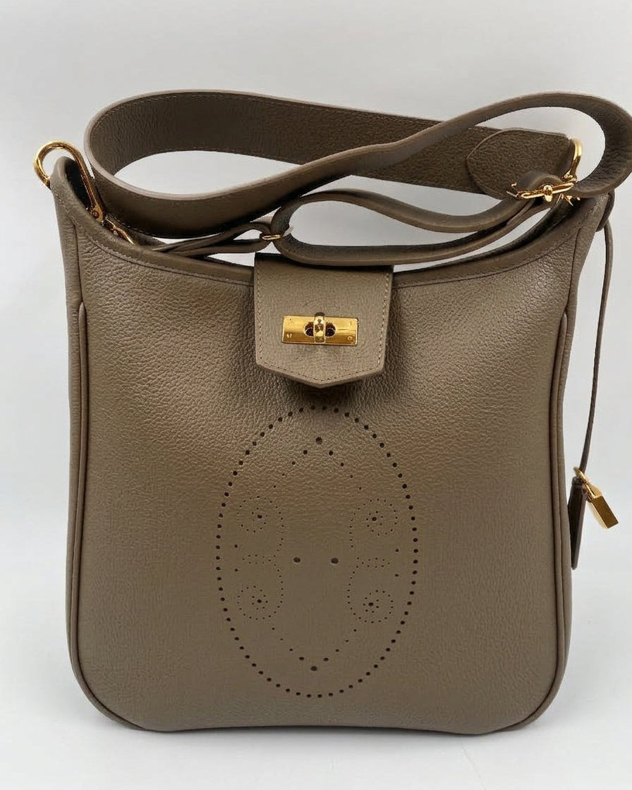 Sac Trianon grand format en cuir taupe vue de face, motif perforé bout fleuri, fermoir tournant doré, cadenas et large bandoulière en cuir, fabriqué en France par Berthille